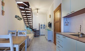 A kitchen with a sink, cabinets, and a staircase leading to another room. - Casa Giacomo - Two Bedroom Apartment, Sleeps 4 (Villasimius)