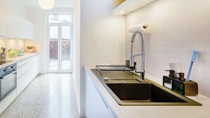 Eine moderne Küche mit integriertem Spülbecken, einer Hängelampe und einem Fenster mit Ausblick.