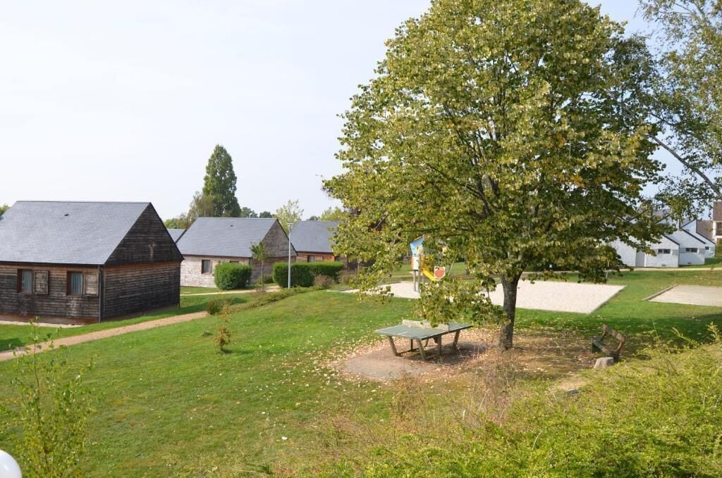 A residential area with houses, a tree, and a picnic table.