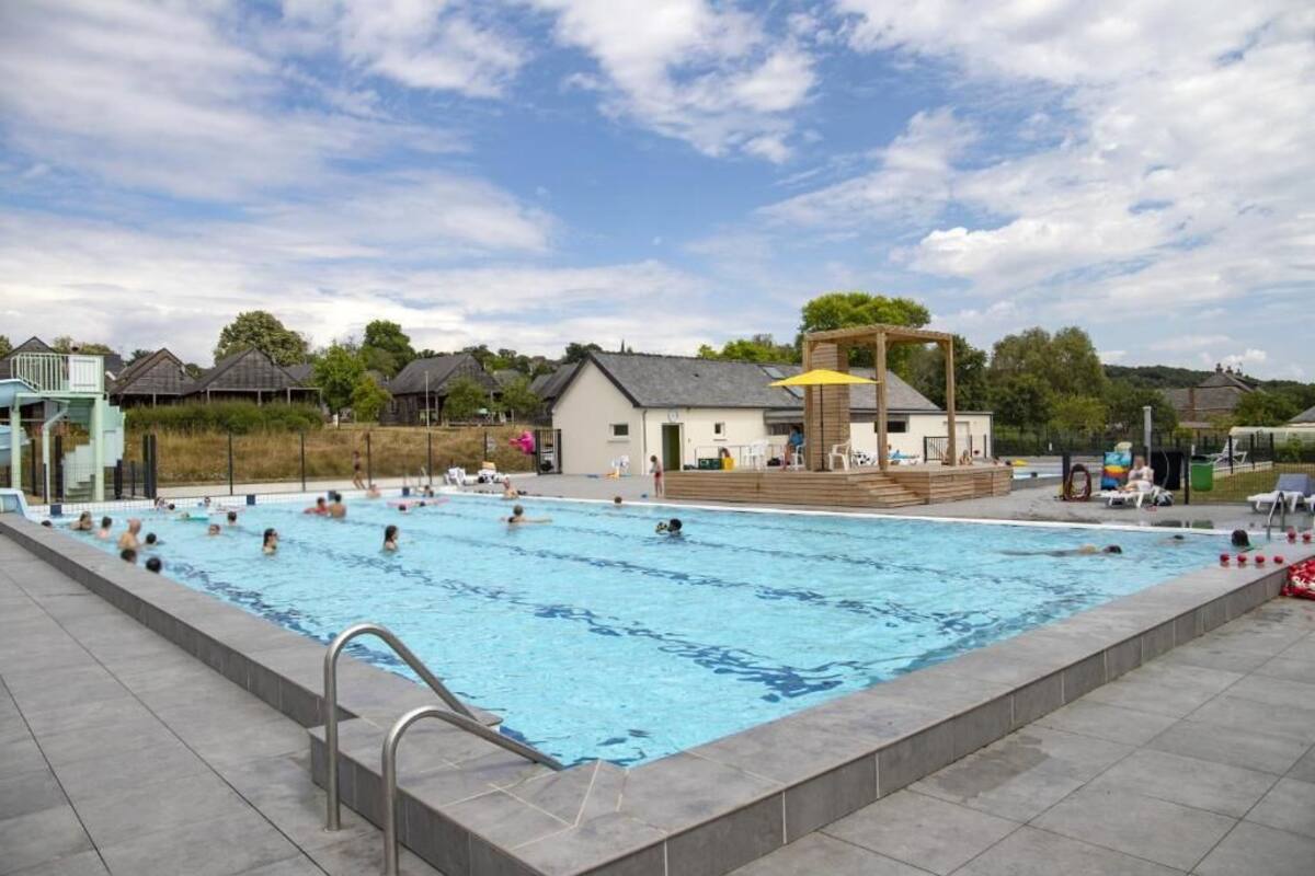 A swimming pool with a wooden deck and a lifeguard stand.