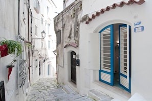 A narrow street with a white building, a blue door, and a small sign. - La Giosa Holiday Home (Sperlonga)