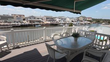 Eine Terrasse mit Tisch und Stühlen mit Blick auf eine Marina mit Booten und Häusern.