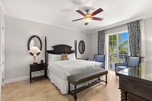 A bedroom with a bed, bedside tables, a bench, a ceiling fan, and a view of the outdoors. - Ocean Front Two Bedroom Residence (Key West)