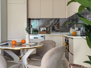 A modern kitchen with a marble backsplash, a Siemens dishwasher, and a coffee machine. - Qoople Legend A9 Apartment 1+1 in Alanya (Alanya)