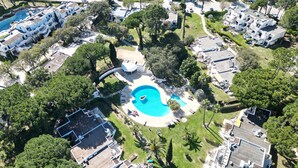 Ett flygbildsfoto av ett bostadsområde med en swimmingpool, flera hus och en liten vattenrutschkana.
