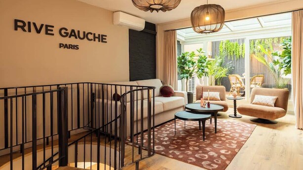 Ein modernes Wohnzimmer mit Treppe, einer Couch, einem Couchtisch und einem Esstisch.
