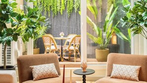 Ein gemütlicher Innenbereich mit zwei Sofas, einem runden Tisch und einem Blumentopf.