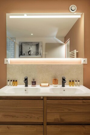 A bathroom with a double sink, a mirror, and a wooden cabinet below. - Rare loft with a stylish patio - Eiffel Tower (Paris)
