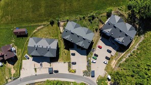 Una vista aerea di una zona residenziale con due case grandi, un parcheggio e una strada.
