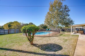 A backyard with a swimming pool, a covered patio, and a fenced area. - Private Pool • Fenced Yard • Covered Patio (Decatur)