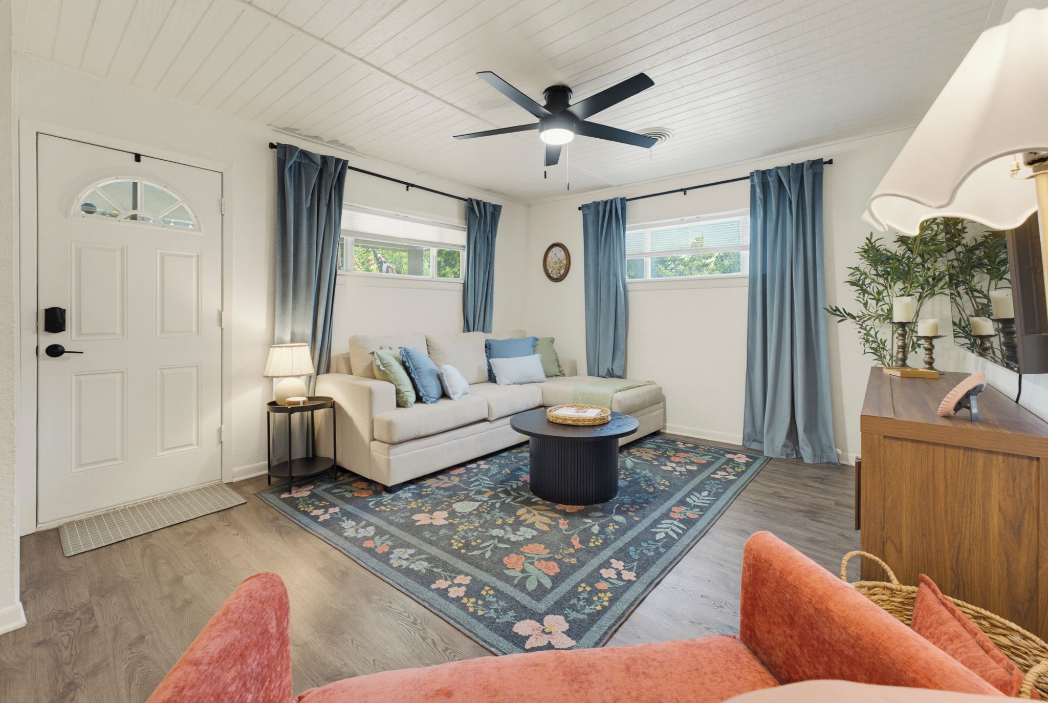 Ein Wohnzimmer mit Sofa, Couchtisch und Deckenventilator.
