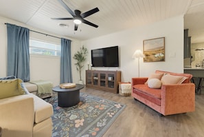 A living room with a sofa, a coffee table, a television, and a painting on the wall. - Kid friendly + 3 blocks from Decatur Courthouse! (Decatur)