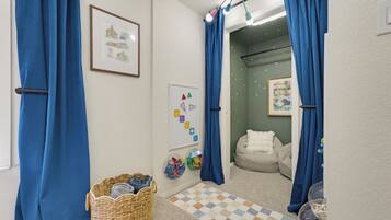 A bathroom with a checkered floor, a wicker basket, a whiteboard, and a dog bed.