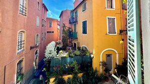 A narrow street with colorful buildings, a small garden, and a blue staircase. - Cocon du Senat 2 - Old Town (Niza)