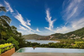 A swimming pool with a view of a lake and hills. - Luxury Livving Steps from La Ropa - 2Br 2 Bath (Zihuatanejo)
