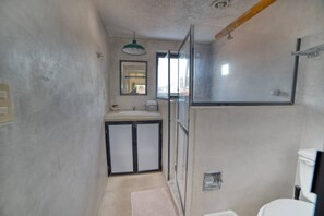 A compact bathroom with a shower, a sink, and a toilet. - Loft con Jacuzzi Privado (Ixtapa)