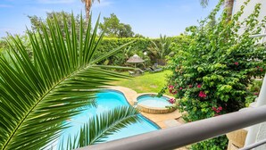 A swimming pool with a hot tub, surrounded by lush greenery and a small gazebo. - The Oceana (Cape Town)