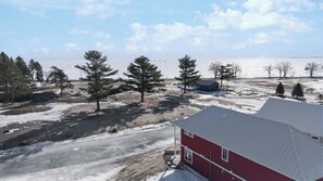 A red building with a metal roof, surrounded by snow-covered ground and sparse trees.
