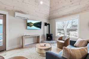 Una sala de estar acogedora con chimenea, televisor y un espacio de descanso confortable.