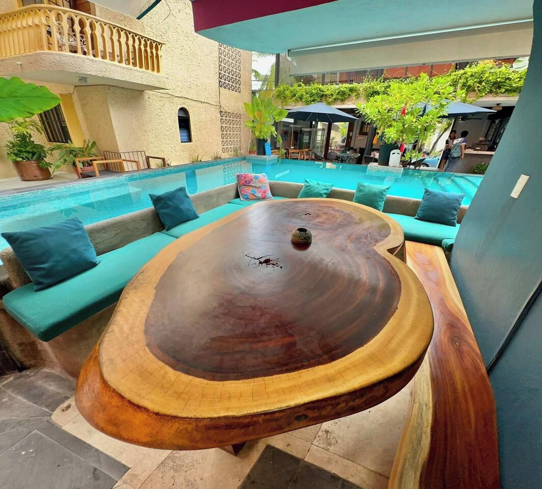 Un espace extérieur aménagé avec une piscine, une table en bois et des chaises longues.