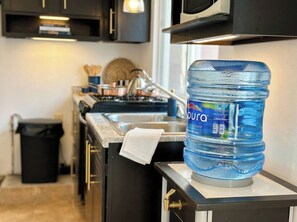 A kitchen with a water dispenser, a sink, and cabinets. - Minimalism Apartment at Ixtapa Zihuatanejo (Ixtapa Zihuatanejo)