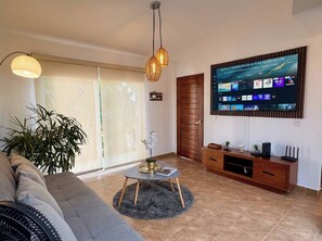 Ein Wohnzimmer mit einer Couch, einem Couchtisch, einem Fernseher und einem Holzschrank.