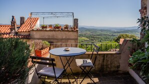 A terrace with a table and chairs, potted plants, and a view of the countryside. - The Nest, Hamlet in Tuscany – Mountain View, Private Terrace & Wi-Fi (Ravi)