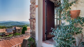 A building with a brick exterior, a dark wooden door, and a view of the countryside. - The Nest, Hamlet in Tuscany – Mountain View, Private Terrace & Wi-Fi (Ravi)