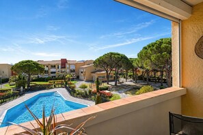 Zona de piscina con vistas despejadas a los edificios y la vegetación circundantes.