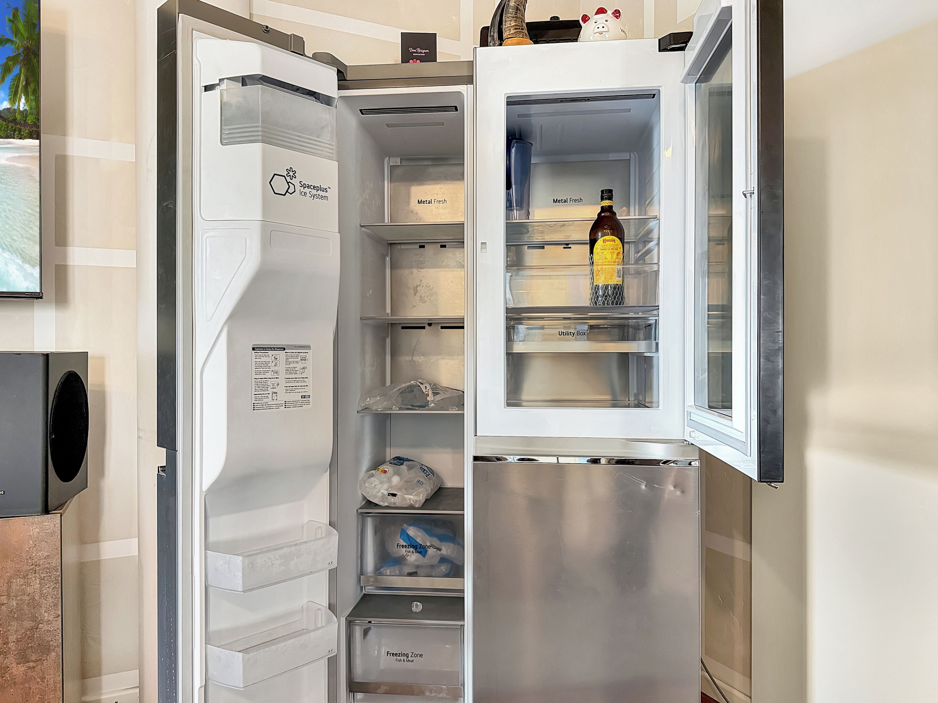 Ein Kühlschrank mit mehreren Fächern, darunter eine Gefrierzone für Fisch und Fleisch, eine Eierablage und ein Fach mit der Aufschrift 'Metal Fresh'.