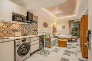 Un espacio habitable compacto con lavadora, microondas y una pequeña kitchenette.