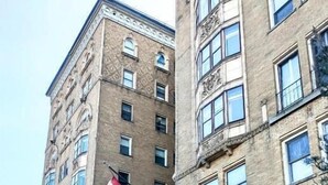 A hotel with a classic brick facade, a glass entrance, and flags. - Lenox Hotel and Suites (Buffalo)