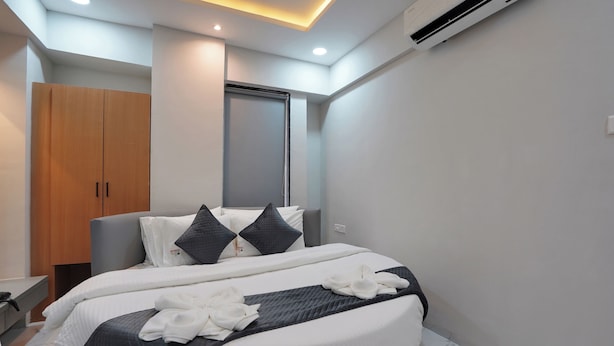 Una camera d'albergo moderna con un letto grande, un armadio, una scrivania e un bagno.