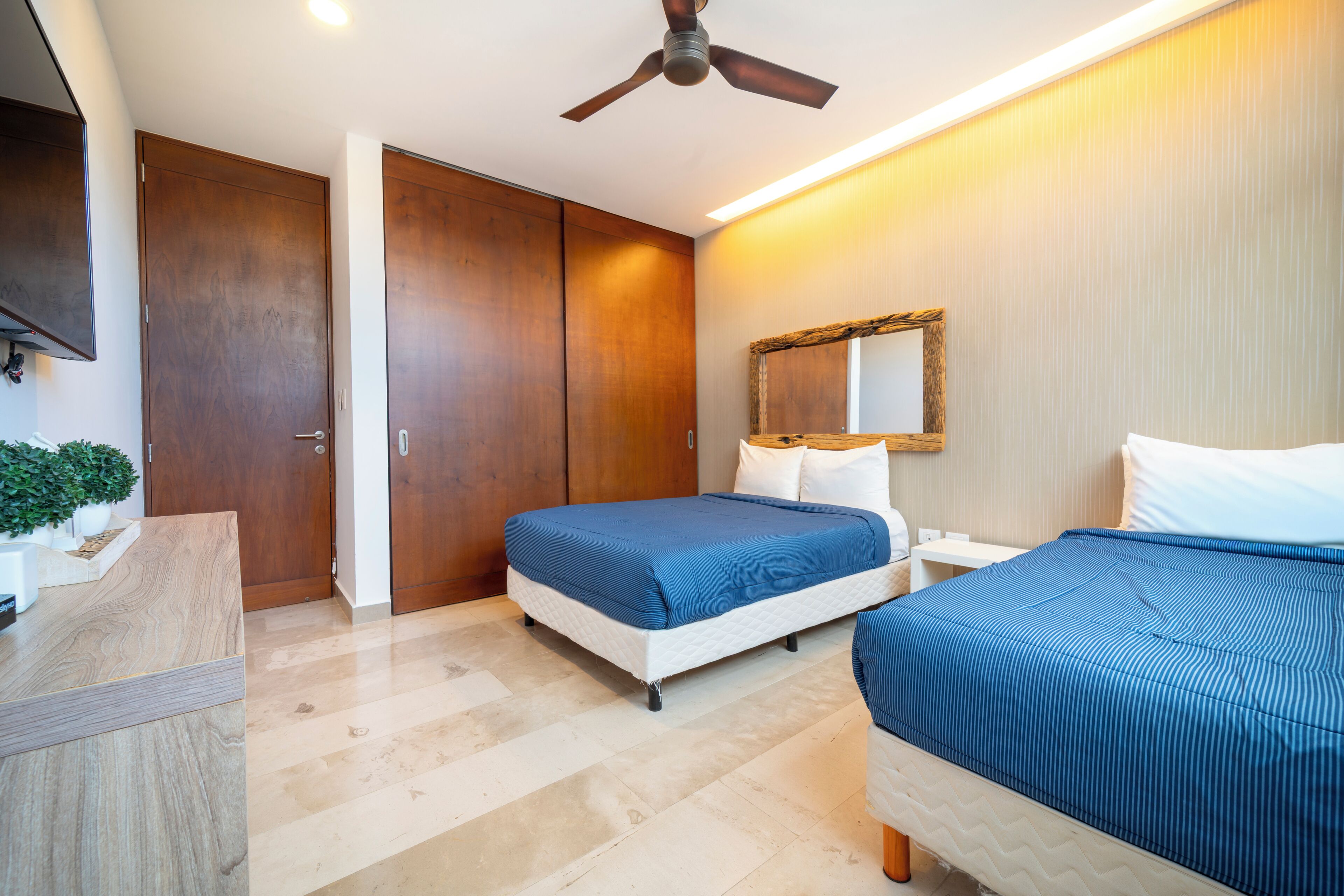 A bedroom with a bed, bedside table, and a ceiling fan.
