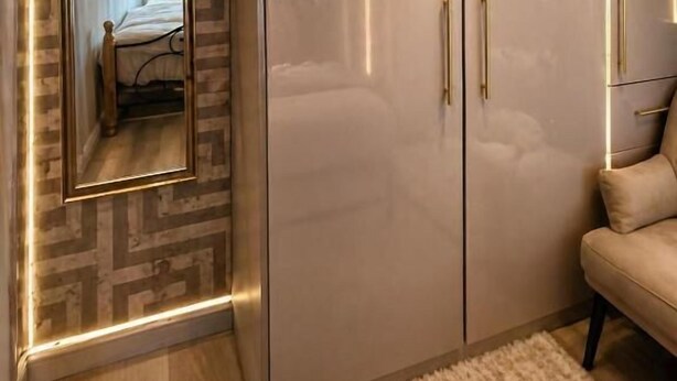 A bedroom with a large wardrobe, a mirror, and a bed. - RS Prime Homestay (Solihull)