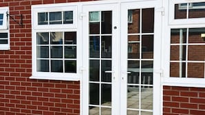 A red brick house with white-framed windows and a sliding glass door. - RS Prime Homestay (Solihull)