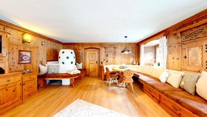 Ein gemütliches Blockhaus-Interieur mit Holzwänden, einer Essecke und einer Couch.