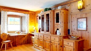 Ein Holzinnenraum mit Fenster, Stuhl und einer Kommode mit Schubladen.