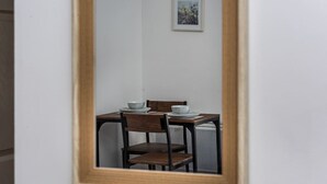 Taula de dinar amb cadires i un bol, emmarcat per un mirall.