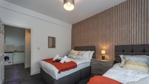 Una camera d'albergo con un letto, un comodino e vista sulla cucina.