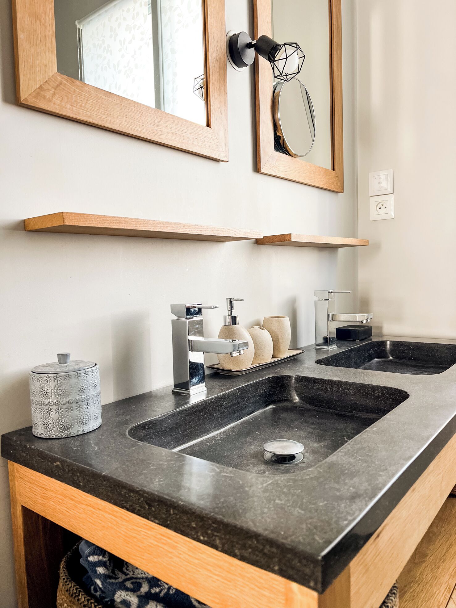 A modern bathroom with two sinks, a mirror, and a towel rack.