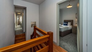 A bedroom with a bed, bedside table, and a nightstand. - 5 Bed Home • Parking • Ideal for Contractors (Carmarthenshire)