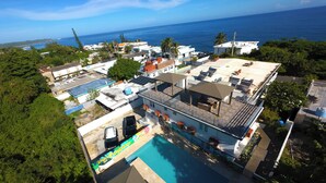 Vista aèria d'un complex turístic amb piscina, diversos edificis i vistes a l'oceà.