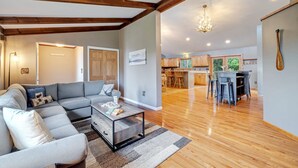 A spacious living room with a sectional sofa, a coffee table, and a kitchen in the background. - Mountain Views Private Pond Mins 2 Elk Mountain (Union Dale)
