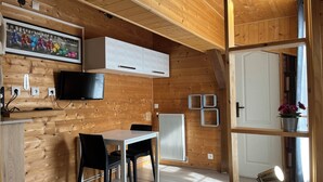 Un intérieur en bois comprenant un coin repas, un téléviseur et un radiateur.