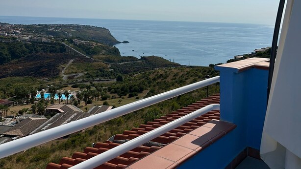 A balcony with a view of the sea, a swimming pool, and a hilly landscape. - STILL HOUSE 1904 (San Nicola Arcella)
