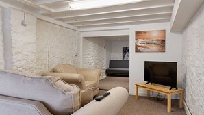 A living room with a sofa, armchair, TV, and artwork on the wall. - 1 Bed Home • Parking • Great for Contractors (Gorseinon)