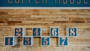 A hotel wall with a wooden plank design and numbered room blocks from 1 to 8.