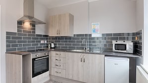 A compact kitchen with a built-in oven, a microwave, and a sink.