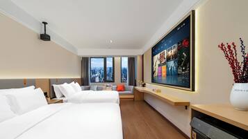 A hotel room with two beds, a large TV screen, a city view, and a modern design.